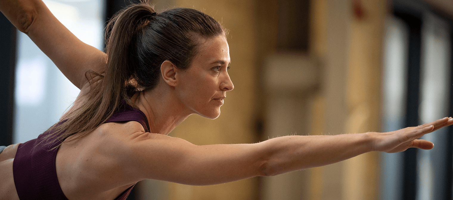 Lady focused on balancing doing yoga